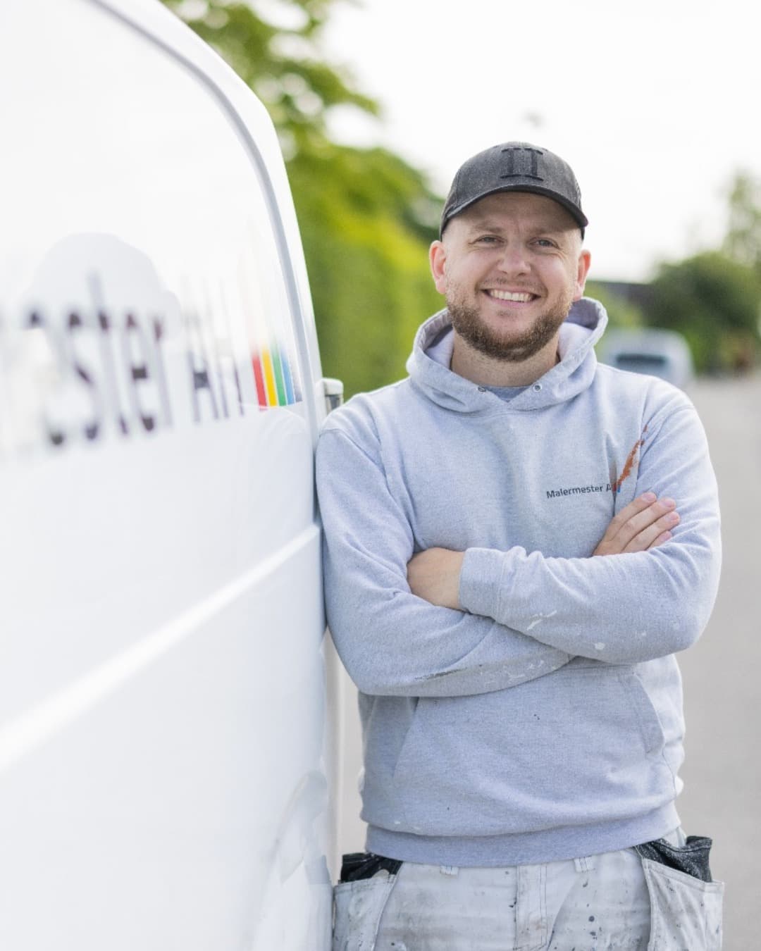 Maler fra Malermester AH lænet op ad firmabilen