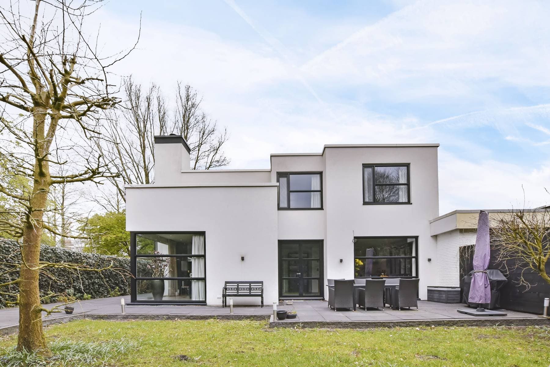Hvidpudset funkisvilla med sorte vinduer og nyrenoveret facade