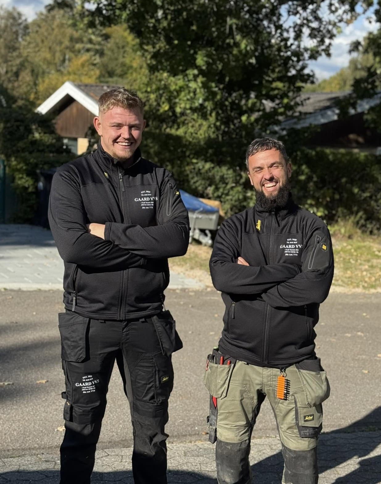 To VVS-installatører fra GAARD VVS i arbejdstøj foran et hus