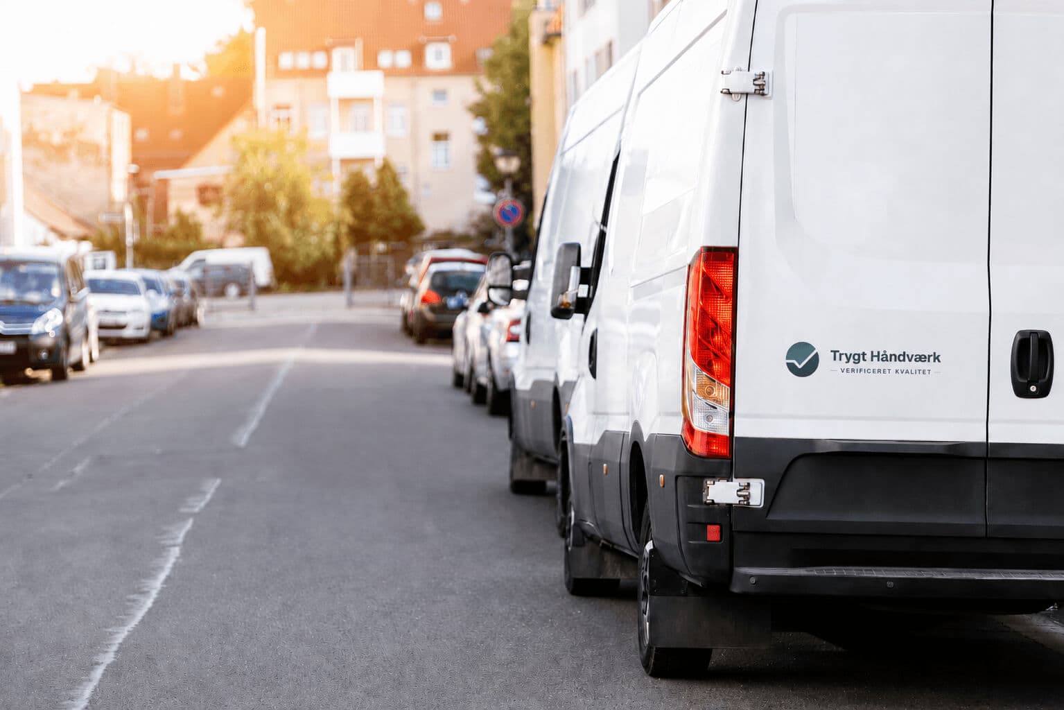 Hvid varevogn med Trygt Håndværks logo parkeret i en boliggade